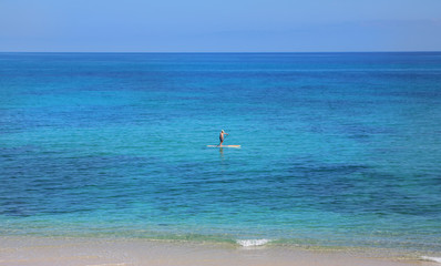 One man on a paddle board on the ocean in Baja. 