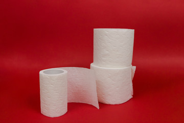 Three rolls of toilet paper on red background