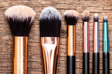 Fototapeta premium Set of makeup brushes on wooden background.