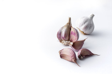 garlic cloves and garlic bulb and white background