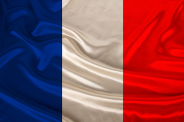 photo of the national flag of France on a luxurious texture of satin, silk with waves, folds and highlights, closeup, copy space, concept of travel, economy and state policy, illustration