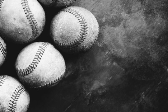 Baseball background with group of used dirty balls view from above in black and white.