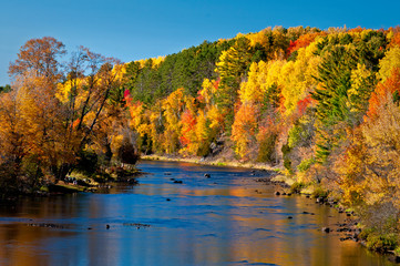 Vivid autumn colors reflected in the Paint River at Crystal Falls, Michigan.