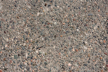 Grey asphalt with multi-colored stone chips close-up. Concrete textured background.