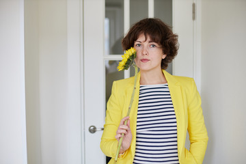 woman in a yellow jacket with a sunflower smile