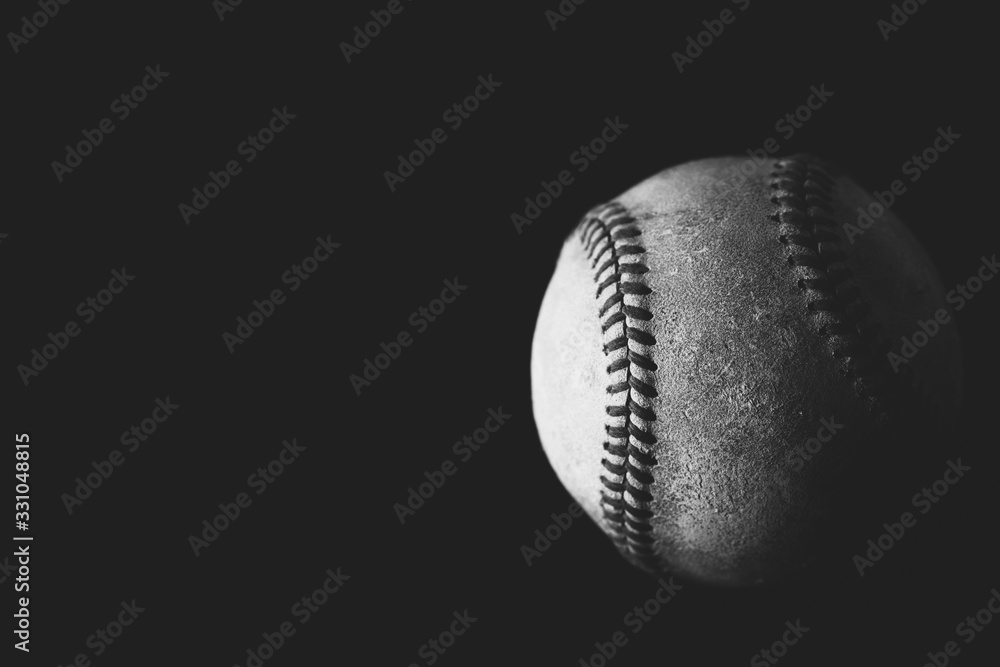 Poster baseball ball in dark lighting close up, black and white sports image with copy space isolated on bl - Posters