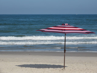 Empty beach and parasol with no people on the sand