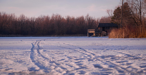 Obraz premium Frozen pond lit with pink sunset sun rays in Unionville, Markham, Ontario, Canada