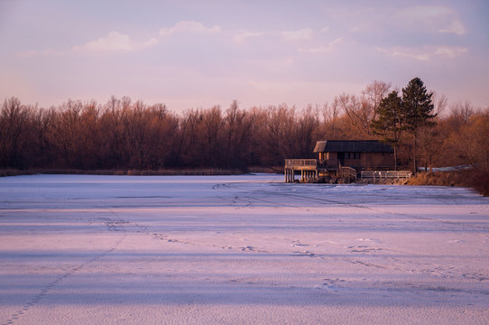Frozen pond lit with pink sunset sun rays in Unionville, Markham, Ontario, Canada