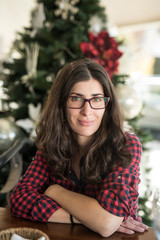 Pretty woman with glasses portrait with christmas tree in background