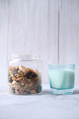  mixed nut , milk on table against white wall 