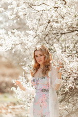 Fototapeta na wymiar Pretty woman in blossom spring garden