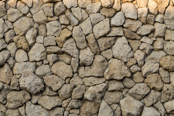 Background of limestone masonry. The surface is decorated with natural material. The wall is made of wild stone.