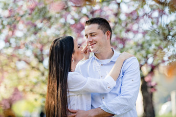 Beautiful young couple in love outside in spring nature, hugging.