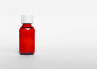 Red medicine glass bottle isolated over white.Single red bottle with drug. Medicine bottle of red glass or Plastic isolated on white background. High resolution photo.