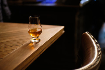 Glass of good whisky in glen glencairn glass on table