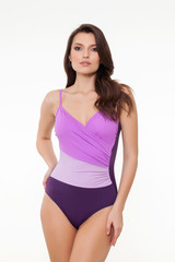 beautiful girl posing in stylish detailed purple swimsuit on white background.