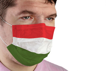 Portrait of adult caucasian man who wears protective mask on his face against influenza and protect health from bacteria. Image of the flag of Hungary.