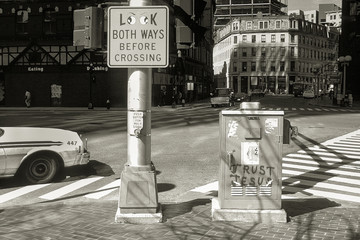 LOOK BOTH WAYS BEFORE CROSSING  next to graffiti sign TRUST JESUS, Boston, Massachusetts