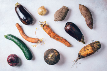 Ugly vegetables on grey background. Ugly food concept. Top view, flat lay.