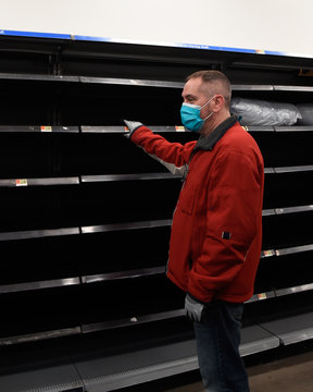 Man In Mask Looking At Empty Grocery Store Shelf