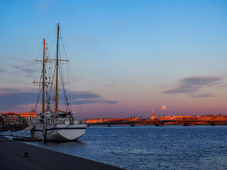 Sunset cityscape with old sailing ship