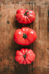 Ugly tomatoes on wooden background. Concept of zero waste production. Top view. Copy space. Non gmo vegetables