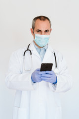 caucasian doctor using protective gloves, mask and mobile phone. Chinese Corona virus concept. 2019-nCoV