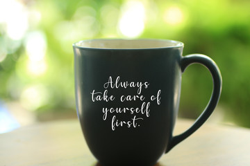 Inspirational quote - Always take care of yourself first. With text on an empty cup on bright green...
