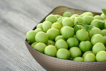 first green sour plums of the year, green plum is very fresh, a container full of green plums,