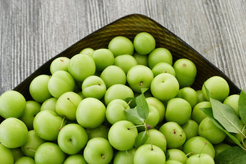 first green sour plums of the year, green plum is very fresh, a container full of green plums,