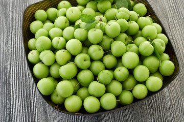 first green sour plums of the year, green plum is very fresh, a container full of green plums,