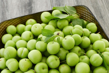 first green sour plums of the year, green plum is very fresh, a container full of green plums,