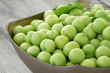 first green sour plums of the year, green plum is very fresh, a container full of green plums,