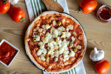 Pizza con jamón, queso, tocino y aceitunas