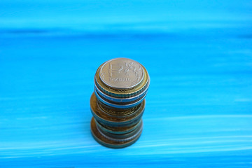 Russian one ruble and a stack of gold coins on a blue background