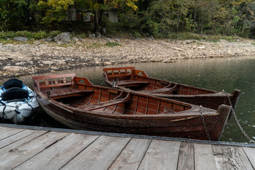 Brown wooden boats moored at the pier on the lake