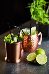 Cuba Libre, Rum and Cola drink with lime in copper mugs on a bar