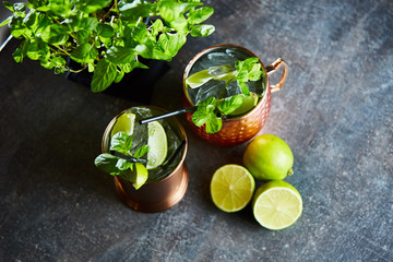 Cuba Libre, Rum and Cola drink with lime in copper mugs on a bar