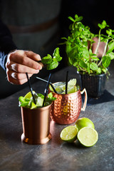 Cuba Libre, Rum and Cola drink with lime in copper mugs on a bar