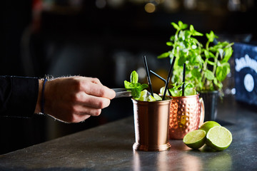 Cuba Libre, Rum and Cola drink with lime in copper mugs on a bar