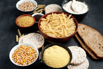 Selection of gluten free food. Chickpeas, bread, couscous, bulgur, pasta, bread, flour, quinoa on a stone background