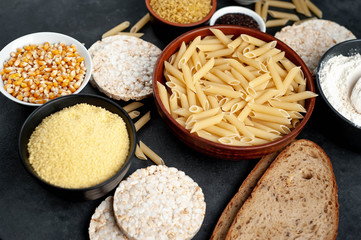 Selection of gluten free food. Chickpeas, bread, couscous, bulgur, pasta, bread, flour, quinoa on a stone background