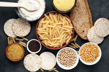 Selection of gluten free food. Chickpeas, bread, couscous, bulgur, pasta, bread, flour, quinoa on a stone background