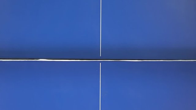 Ping pong concept. Two people playing on a blue table. Close-up top view. Slow motion