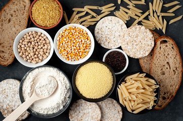 Selection of gluten free food. Chickpeas, bread, couscous, bulgur, pasta, bread, flour, quinoa on a stone background