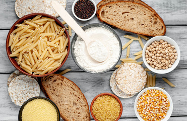 Selection of gluten free food. Chickpeas, bread, couscous, bulgur, pasta, bread, flour, quinoa  on wood background