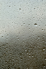 Rain drops on window glasses surface with cloudy background . Natural Pattern of raindrops isolated on cloudy background.