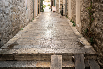 Fototapeta na wymiar Old narrow street of a European city paved with stones