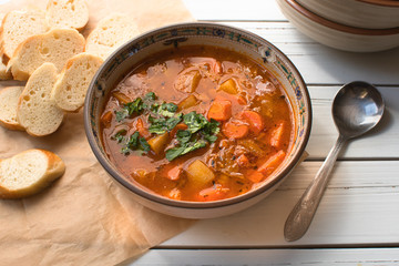 Vegan lentil and vegetables  soup bowl on wooden table